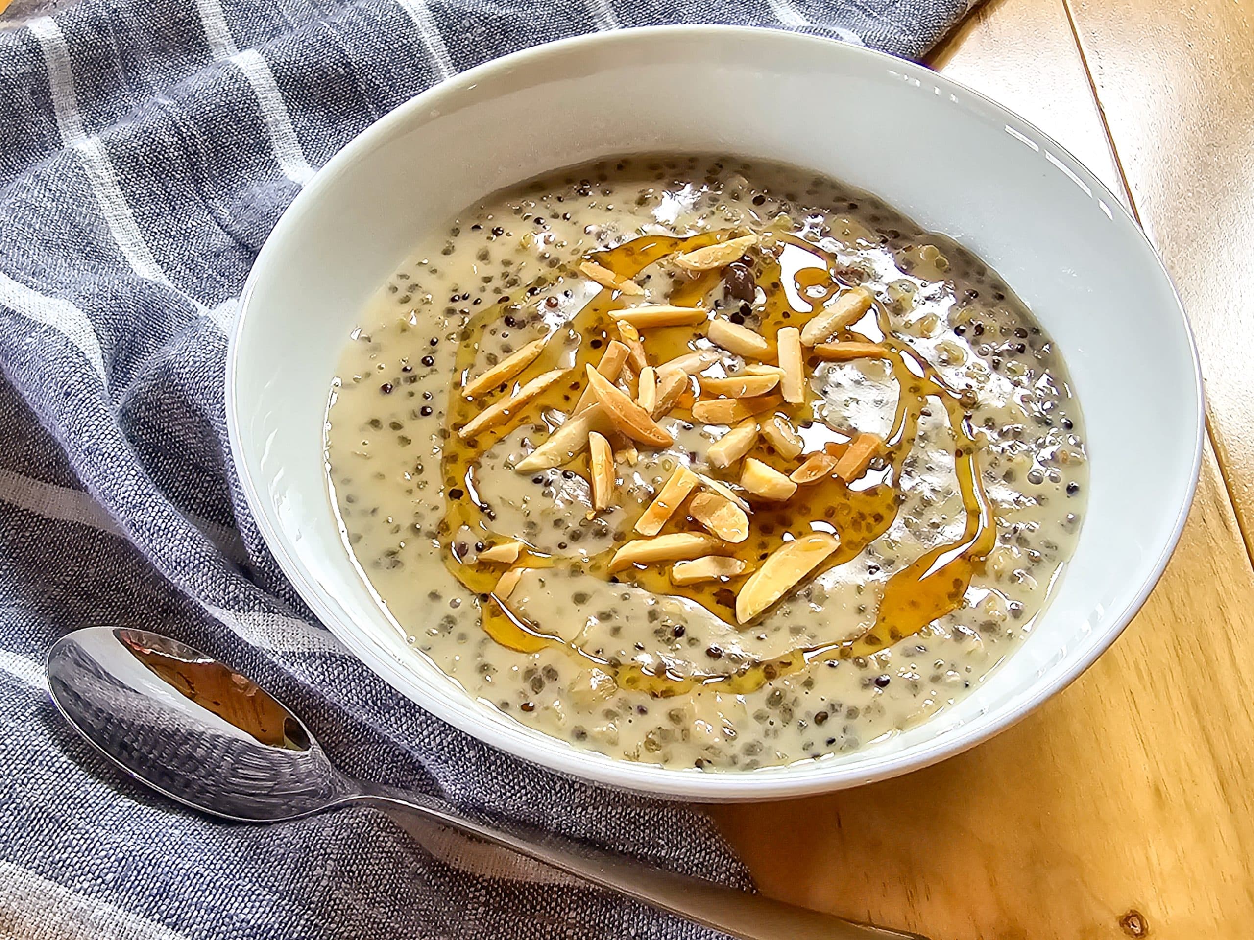 Oatmeal with Quinoa and Chia Seeds topped with slivered almonds and honey in a white bowl