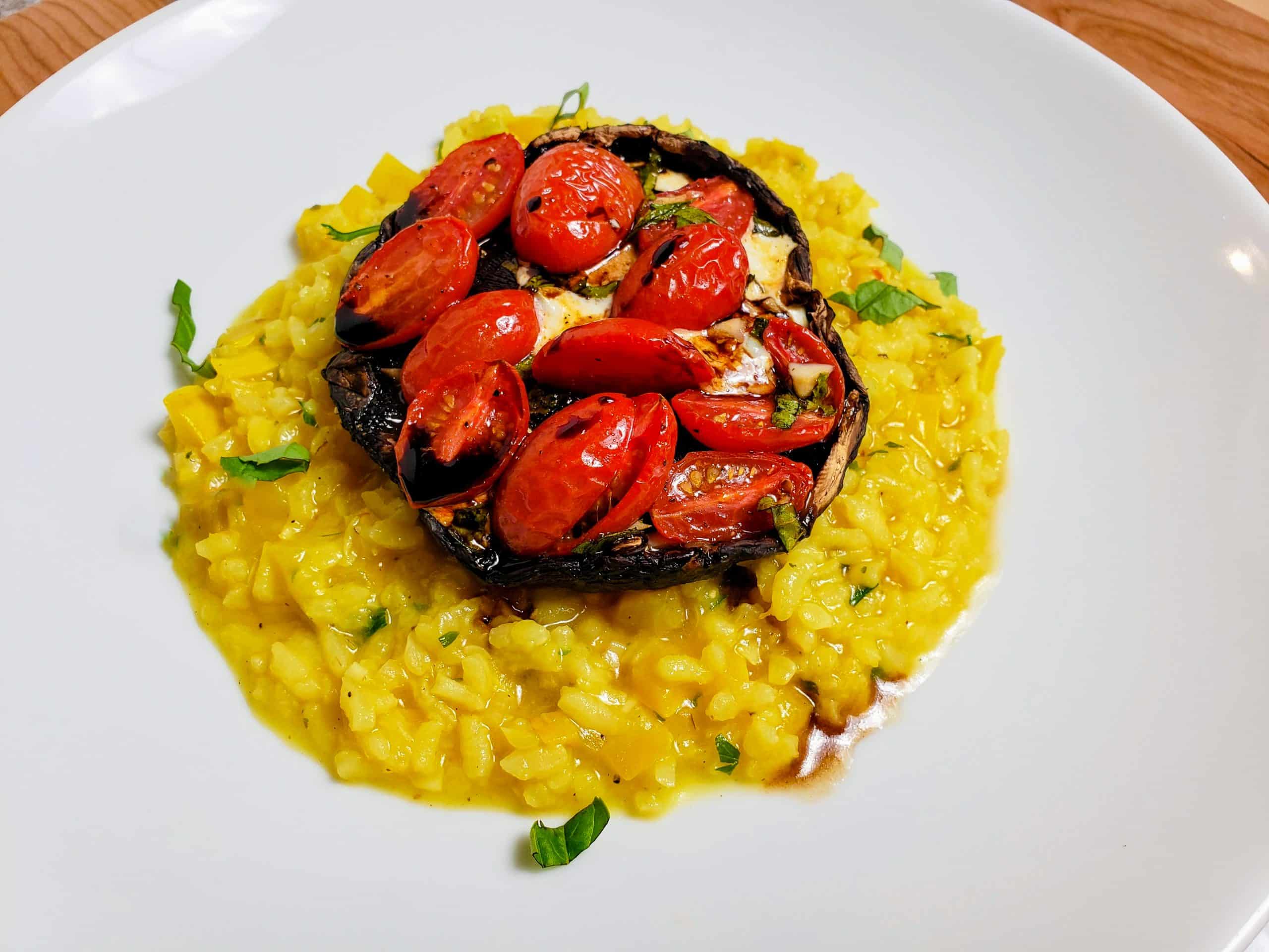 caprese style portobello mushroom over risotto pm a white plate